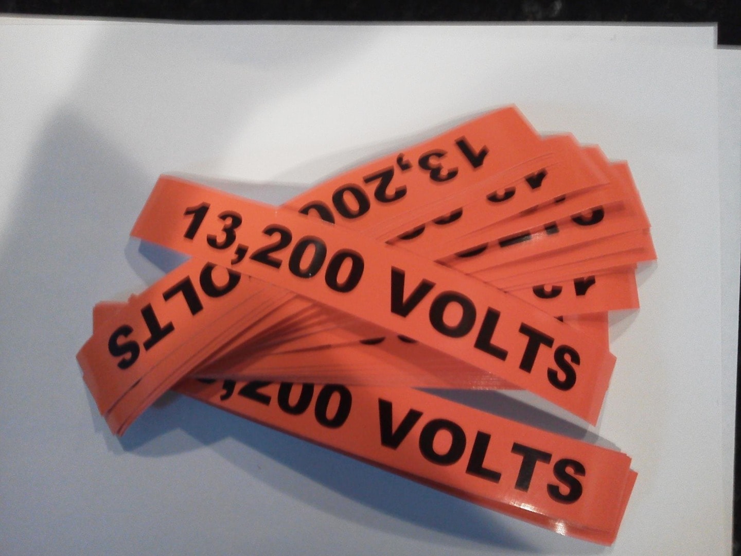Batch of engraved orange vinyl 13,200 Volts warning labels
