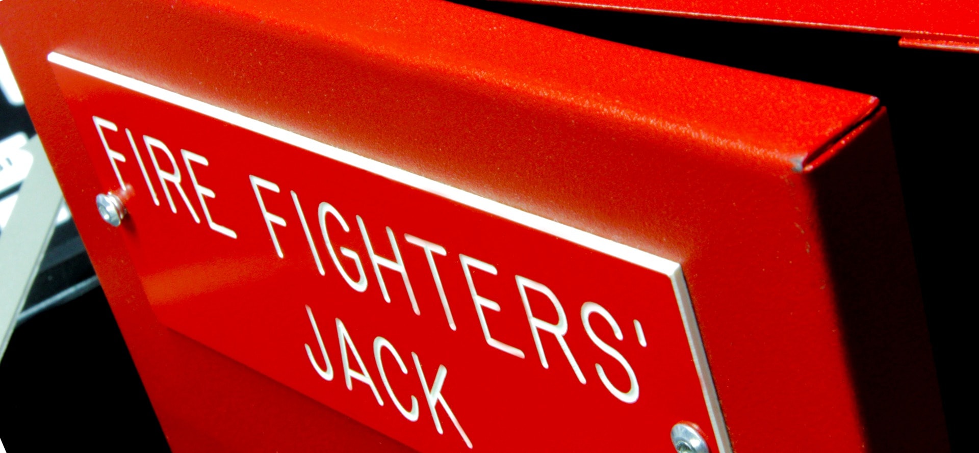 Engraved stainless steel Fire Fighters Jack nameplate mounted on red box