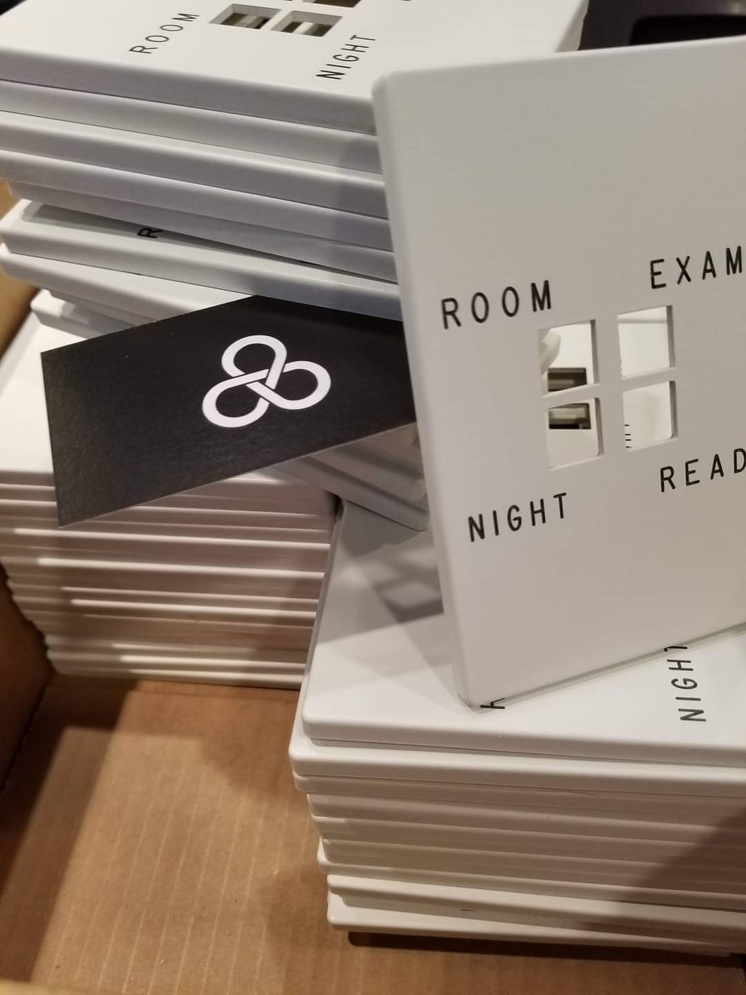 Large batch of engraved white hospital switch plates labeled ROOM, NIGHT, EXAM, READ