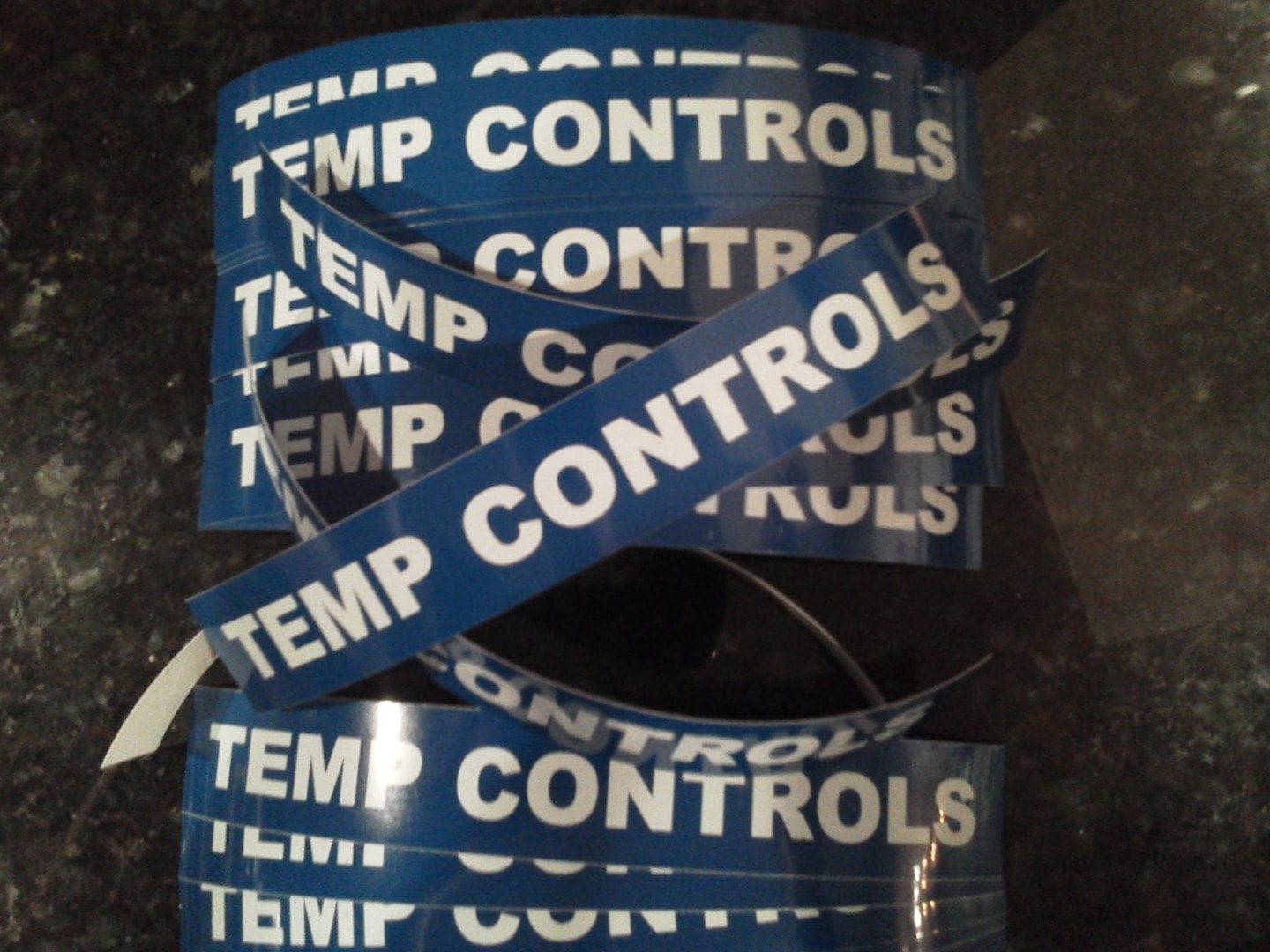 Rolls of blue vinyl tape printed with TEMP CONTROLS in white lettering